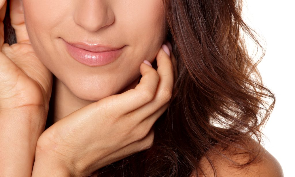 Cropped beauty portrait of woman with hands on face
